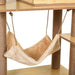 Beige plush cat hammock hanging on rope between brown sisal-wrapped posts on wooden cat tree