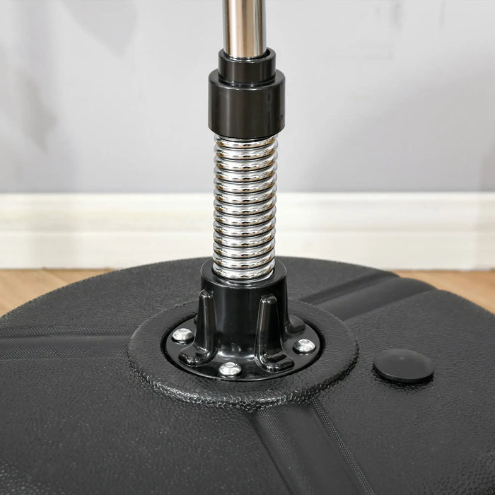 Close-up of black base with metal spring and pipe, floor and gray wall background