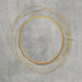 Gold circular mirror with layered design on a gray concrete wall