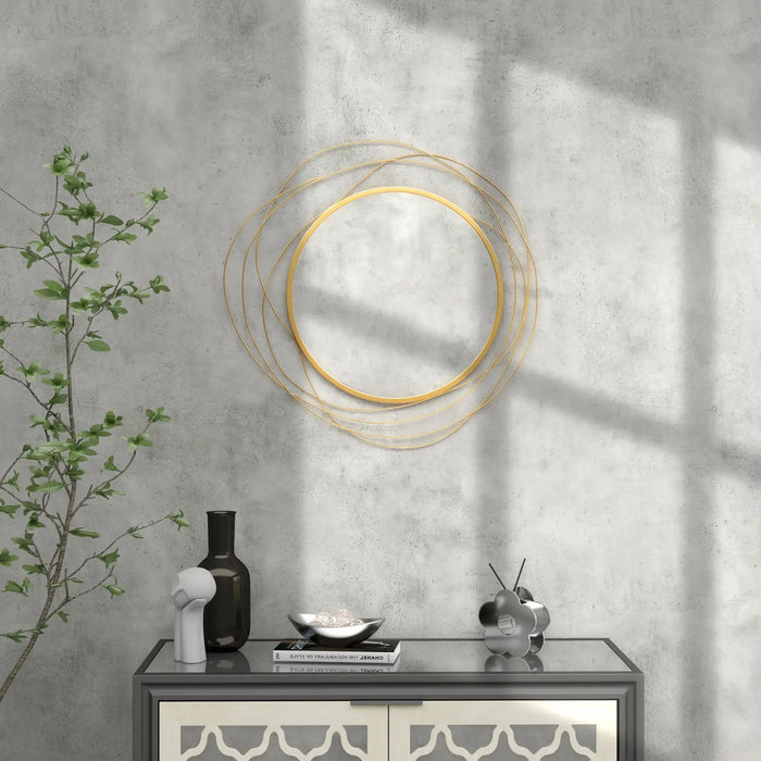 Decorative wall mirror with gold circular frame on a concrete wall with a console table below.