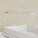 Transparent acrylic enclosure with ventilation holes on a white base against beige textured wall