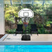 Adjustable portable basketball hoop with weighted base and nylon net by a poolside patio