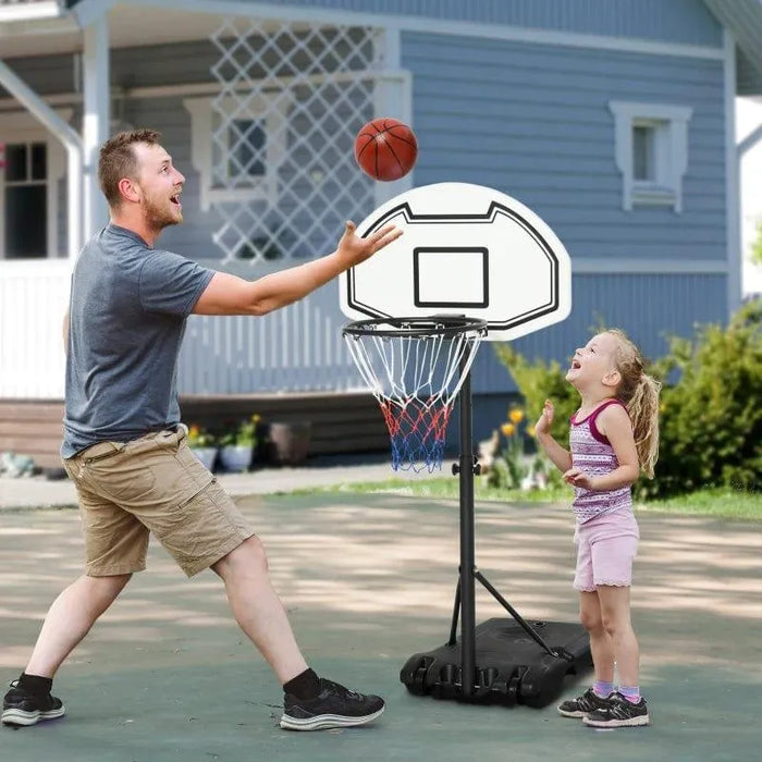 Adult and child playing with adjustable portable basketball hoop outdoors