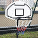 Adjustable portable basketball hoop with nylon net on outdoor court near chain-link fence