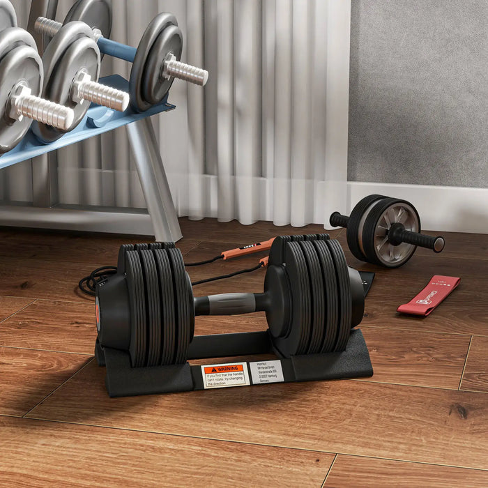 Pair of adjustable dumbbells on a wooden floor with a weight plate set in the background.