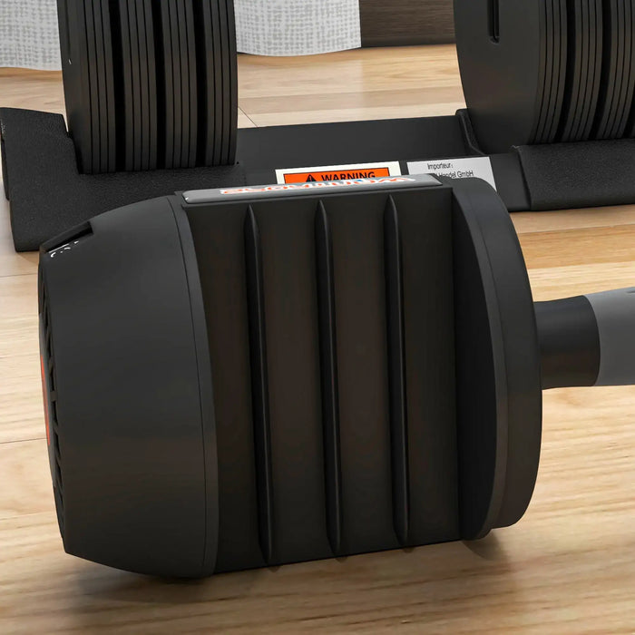 Black dumbbell on a wooden floor with a blurred background