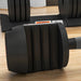 Black dumbbell on a wooden floor with a blurred background