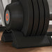 Close-up of a black exercise machine with stacked weights on a wooden floor.