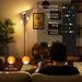 Person using a floor lamp with control panel in a living room