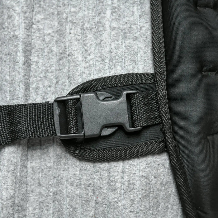 Close-up of a black strap with a buckle on a textured surface