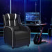 Gaming chair in a dark room with a computer setup and gaming chair.