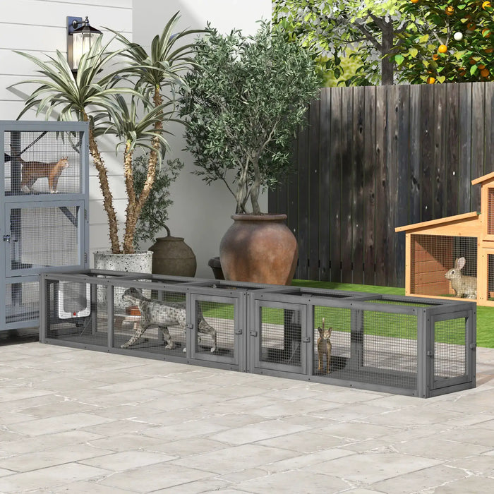 Outdoor pet enclosure with cats inside, potted plants, and a wooden rabbit hutch in backyard