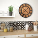 Wooden clock on a wall above a kitchen counter with decorative tiles and jars.