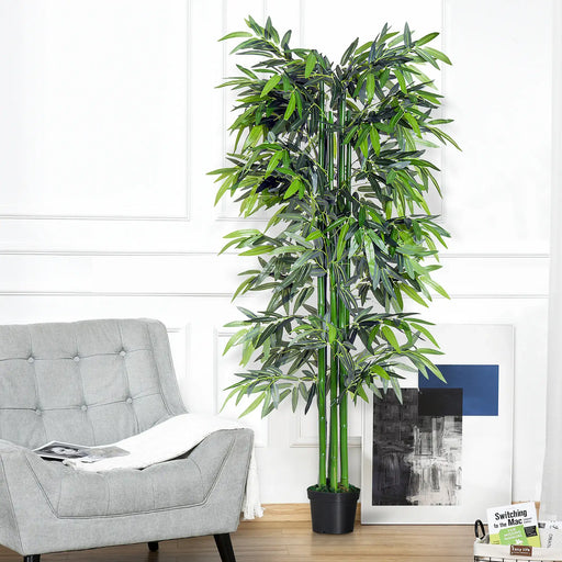 Artificial bamboo plant in a living room setting with a gray sofa and white walls.