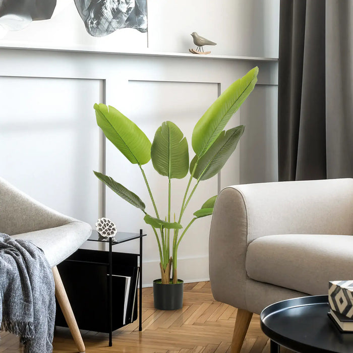 Modern living room with a large green plant, beige sofa, and decorative items.