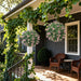 Front porch with ivy-covered railing, two hanging artificial lavender topiary balls, and wicker chairs