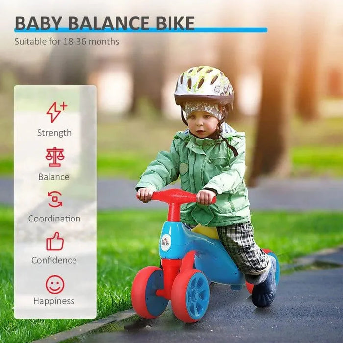 Toddler riding blue, red, and yellow baby balance bike with helmet in a park