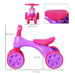 Violet and fuchsia baby balance bike with four rubber wheels, toy bin, and size dimensions.