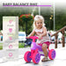 Toddler riding violet and fuchsia baby balance bike with four rubber wheels outdoors