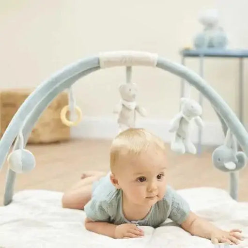 Baby on playmat with arches, hanging toys, rattle and mirror, soft padded activity mat
