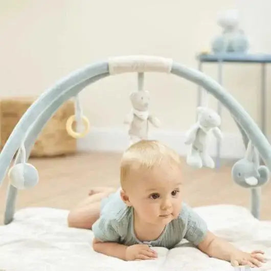 Baby on playmat with arches, hanging toys, rattle and mirror, soft padded activity mat