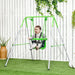 Baby in green toddler swing with safety belt, indoor outdoor setting, white fence background
