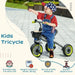Child riding black kids tricycle with adjustable seat, safety features, green wheels outdoors.