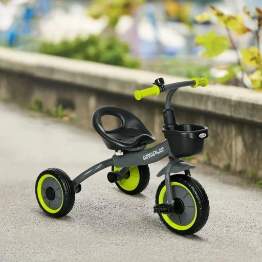 Black baby trike with green wheels, adjustable seat, safety features, and front basket outdoors