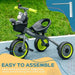 Black and green baby trike with adjustable seat, safety features, front basket, and plush toy