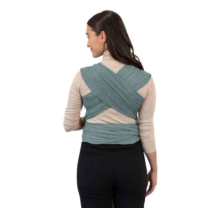 Woman wearing a teal woven wrap on a white background