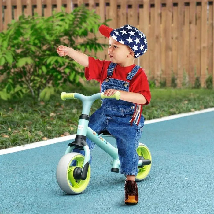 Toddler on balance bike with adjustable seat and EVA wheels outdoors on blue path