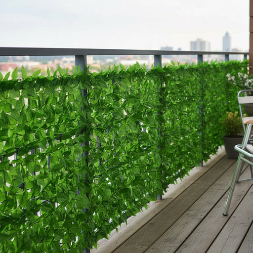 Green leaf balcony privacy screen on outdoor railing with air circulation, wood floor