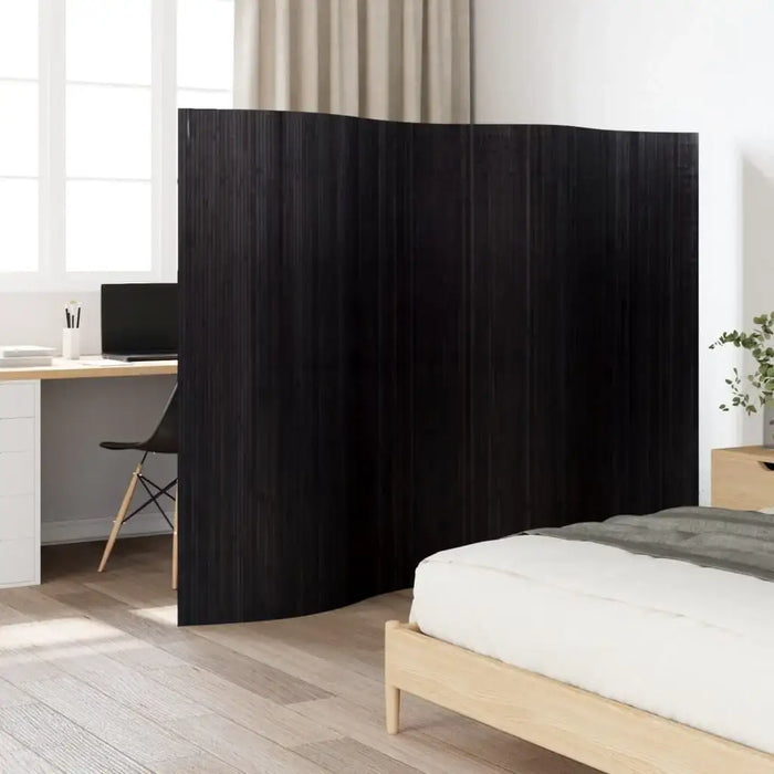 Black room divider in a bedroom setting with a bed and desk.