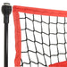 Close-up of baseball training net corner with black mesh and red border on metal pole