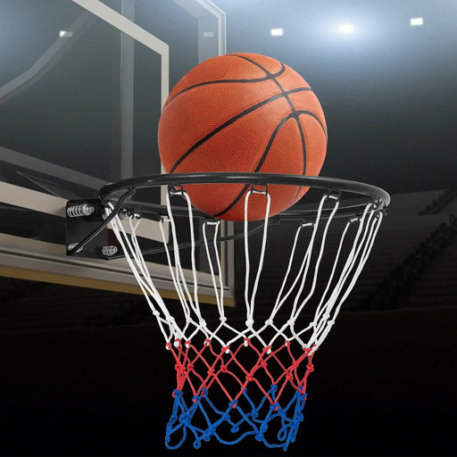 Basketball above black wall-mounted rim with tricolor all-weather net in indoor court
