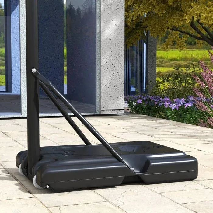 Portable adjustable basketball stand base outdoors on stone patio near modern building