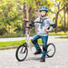 Child wearing helmet rides white big wheel kids scooter with adjustable height in park