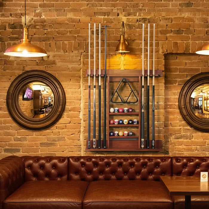 Bar area with pool cues, balls, and decor against a brick wall.