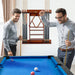 Two men playing pool in a room with a pool table and cue rack.