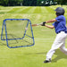 Child in helmet hits baseball toward blue rebounder net on grassy field