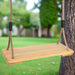 Solid pinewood board swing with adjustable ropes hanging from a tree in a garden