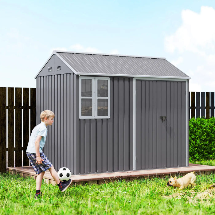 Boy playing soccer in backyard with gray metal garden shed and small dog on grass