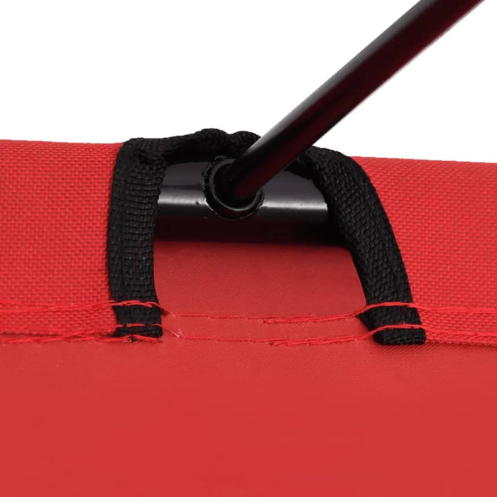 Close-up of red camping bed fabric with black steel frame and reinforced stitching