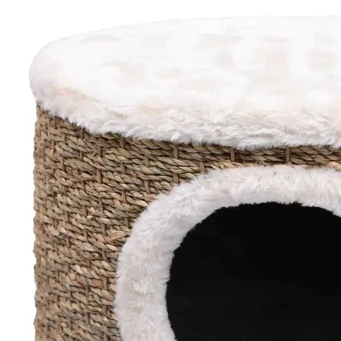 Brown seagrass cat house with white plush top and round entry, elevated cat condo