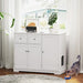 White wooden side cabinet with plant decor and a cat eating food next to it on wooden floor
