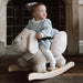 Baby riding plush dog rocker with safety harness and non-tip frame indoors
