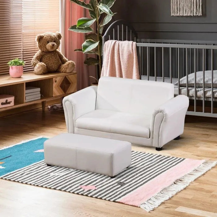 Children's white 2-seater sofa set with matching footstool in a cozy nursery
