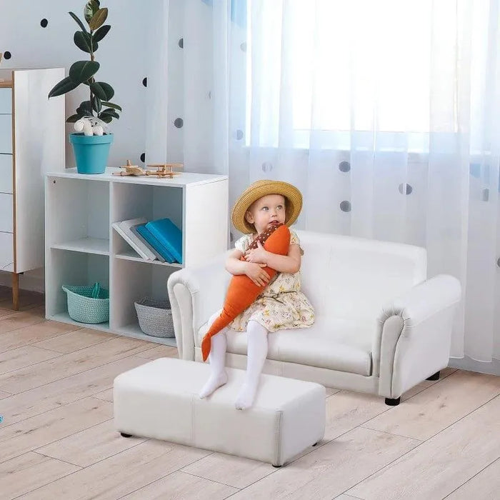 Child sitting on white 2-seater kids sofa with matching footstool in a modern playroom