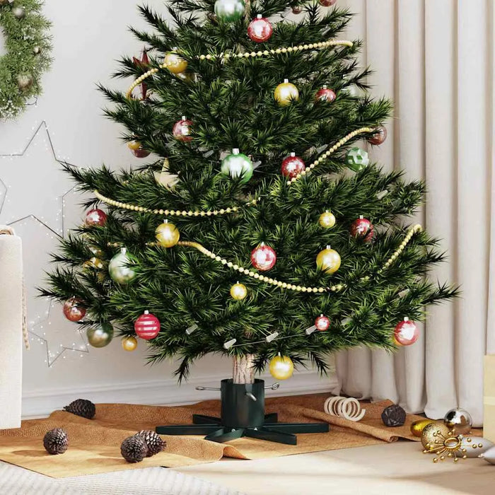 Decorated artificial Christmas tree with gold bead garland and multicolor baubles in cozy living room