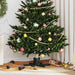 Decorated artificial Christmas tree with gold bead garland and multicolor baubles in cozy living room